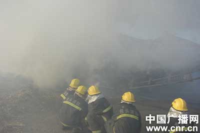 运草车市场旁起火 消防开辟隔离带扑救/图