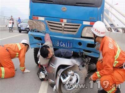 组图：电动车卷车底困1人 消防成功解救