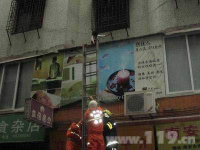 组图：女子被困雨棚上 消防5分钟解救