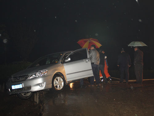 轿车雨天倒车险坠深沟 怀远消防拉车救人