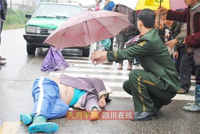 仪陇消防员路为车祸重伤妇女撑伞遮雨