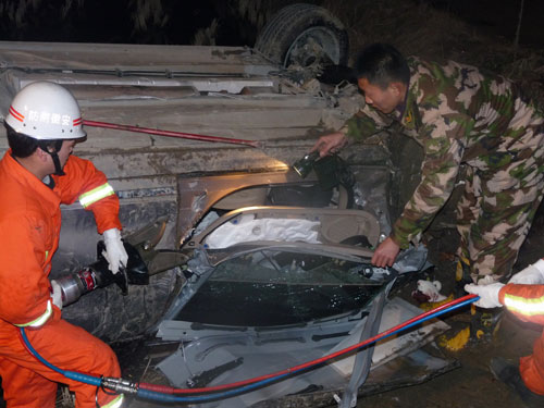 轿车翻下路基四轮朝天 消防破拆救司机