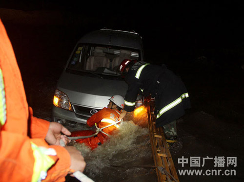 暴雨后小货车河道搁浅困3人 消防救援/图