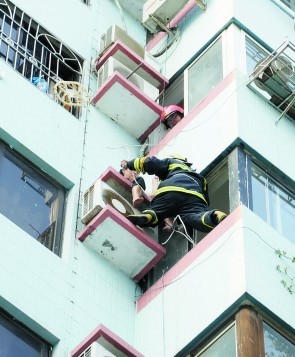 妇女躲到空调室外机上避火 消防紧急施救