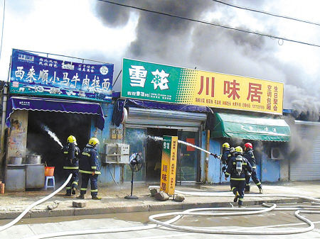 沿街店铺突发火灾蔓延两边 消防迅速灭火/图