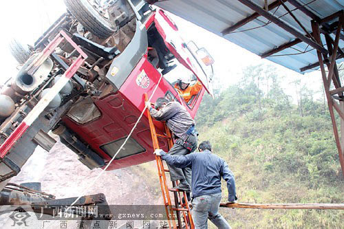 货车卸沙后仰坠坑车头悬空 消防救被困司机