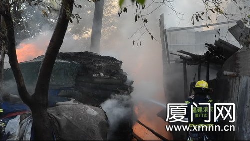 民房前空地发生火灾 现场地毯货物猛烈燃烧