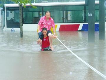 暴雨被困司机骑消防员脖子蹚水引争议