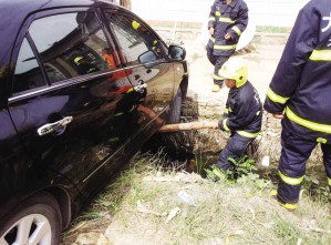 轿车行驶中前轮陷沟中 消防人员及时解难