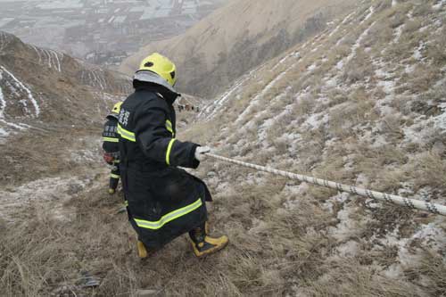 小轿车雪山上冲下深崖 消防搭人梯营救