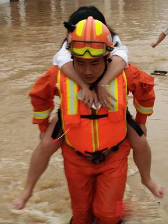 湖南汉寿一村庄遭大水围困 消防员徒步救出被困群众